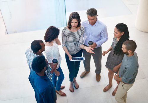 Pooling their brain power. High angle shot of businesspeople talking in the lobby of their office